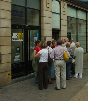 People waiting in line to enter a building.